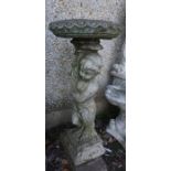 An Antique Stone Garden Plant Stand, Modelled as a classical child holding aloft a torchere, 89cm