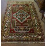 A Persian Hand Knotted Rug, Decorated with a large multi coloured Geometric medallion and further