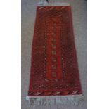 A Persian Bokhara Style Rug, Decorated with ten geometric medallions on a red ground, 150cm x 55cm