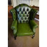 A Chesterfield Green Leather Wing Armchair by Thomas Lloyd, 114cm high