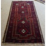 A Persian Bluch Rug, Hand knotted, Decorated with allover geometric motifs on a red and blue ground,