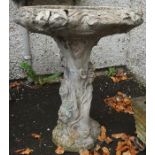 A Stone Garden Bird Bath, Having a circular top, raised on a tree stump style base, 59cm high,