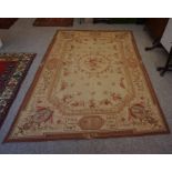 An Old Needlepoint Rug, Decorated with allover floral motifs, on a beige ground, 255cm x 170cm