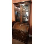 A Georgian Style Oak Bureau Bookcase, Having two glazed doors enclosing a shelved interior, above