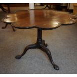 A George III Mahogany Snap Action Supper Table, Having a shaped guinea style circular top, raised on