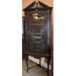 A Mahogany Corner Cabinet on Stand, circa 19th century, Having a carved pediment, above an