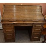 An Oak Roll Top Desk, circa early 20th century, Having a tambour shutter enclosing a fitted