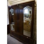 An Edwardian Mahogany Wardrobe, Having two mirrored doors enclosing hanging space, above two small