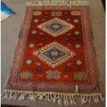 A Turkish Knoya Rug, Decorated with geometric medallions and motifs, on a red ground, 150cm x 110cm