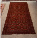 A Bluch Rug, Decorated with multiple geometric medallions, on a red ground, 198cm x 108cm