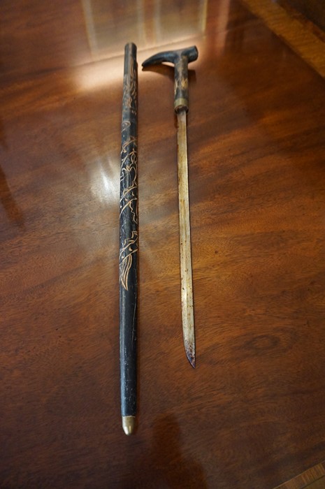 An African Style Ebonised Sword Stick, Decorated with carved panels, blade 48cm long, overall 96cm