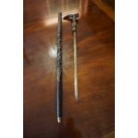 An African Style Ebonised Sword Stick, Decorated with carved panels, blade 48cm long, overall 96cm