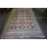 A Pakistani Carpet, Decorated with seven rows of three pink geometric medallions, on a cream ground,