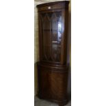 A Reproduction Corner Cabinet, Having a glazed door enclosing a shelved interior, above a cupboard
