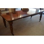 A Victorian Mahogany Wind Out Dining Table, Having three additional leaves, raised on baluster