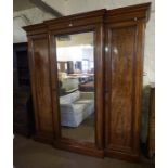 A Victorian Mahogany Breakfront Three Door Wardrobe, Having a moulded cornice above a mirrored door,