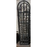 A Wrought Iron Wine Rack, Having a door enclosing 36 bottle inserts, 130cm high, 29cm wide, 35cm