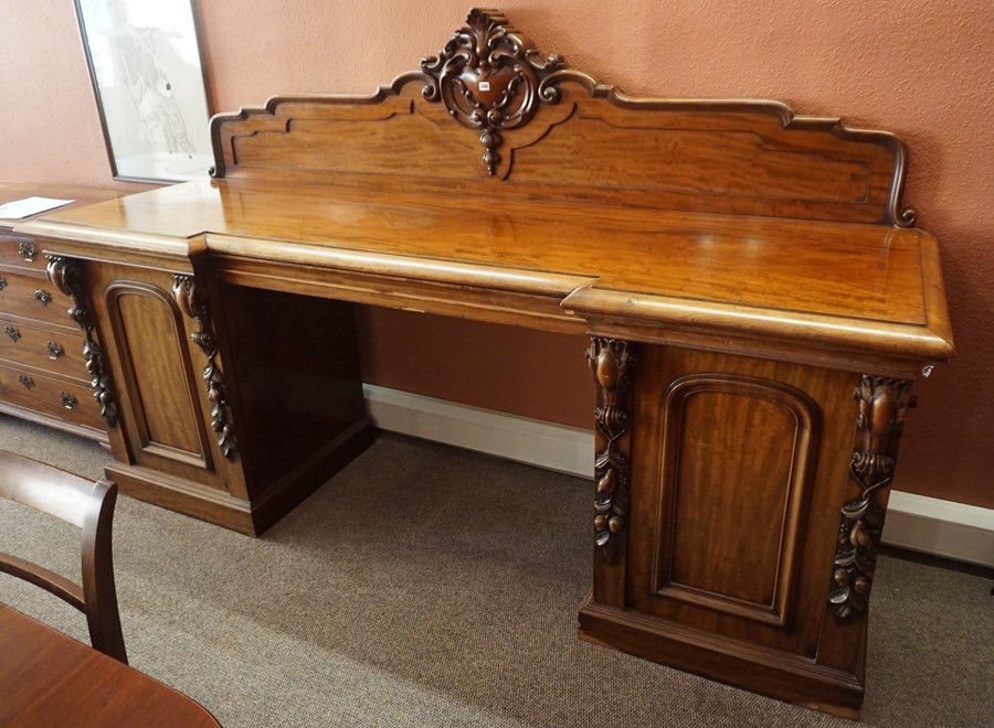 A Victorian Scottish Mahogany Pedestal Sideboard, Having a carved pediment, decorated with scrolls