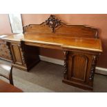 A Victorian Scottish Mahogany Pedestal Sideboard, Having a carved pediment, decorated with scrolls