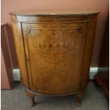 A Walnut Demi Lune Cupboard, Having a cupboard door enclosing two small drawers, raised on