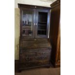 An Oak Bureau Bookcase, circa 18th century, The bureau section having a fall front, enclosing fitted