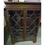 A George III Style Mahogany Inlaid Bookcase, Having two glazed astragal doors, enclosing a shelved