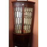 A Mahogany Corner Cabinet, Having two glazed astragal doors, enclosing glass shelves, above two