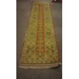 A Milas Runner, Decorated with allover geometric motifs, on an orange and beige ground, 285cm x