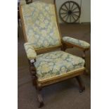 An Oak Framed Rocking Chair, Upholstered in later floral fabric, raised on castors, 99cm high