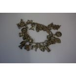 A Silver and White Metal Charm Bracelet, Stamped silver and Sterling to some of the charms,