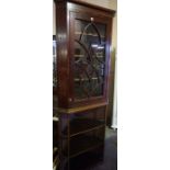 A George III Mahogany Corner Cabinet, Having a glazed astragal door, enclosing a shelved interior,