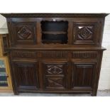 An Oak Press / Cupboard, 20th century, Having an open recess, flanked with a carved door, above