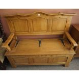 A French Oak Settle / Hall Bench, Having a hinged seat, decorated with metal strap work, 100cm high,
