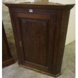 A George III Oak Corner Cupboard, Having a cupboard door enclosing a shelved interior, 94cm high,