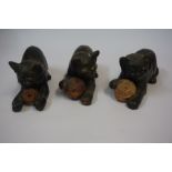 Three Similar Bretby Terracotta Cat figures, each figure having glass eyes and holding a ball,