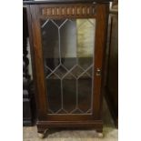 A Modern Oak Cabinet, Having a glazed door enclosing a shelved interior, raised on castors, 104cm