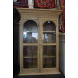 A Pine Display Cabinet, Having two glazed doors, enclosing a shelved interior, crack to one glass