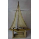 A Model Painted Pond Yacht, raised on a fitted stand, 95cm high, with loose drawings and parts