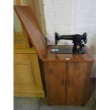 A Vintage Singer Treadle Sewing Machine, number EF 523166, Enclosed in a walnut cabinet, cabinet