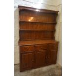 A Stained Pine Dresser, Having open shelving above three small drawers and three cupboard doors,