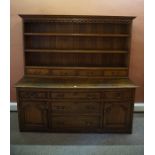 George III Oak Welsh Dresser, the top section having open delft racks above four small drawers,