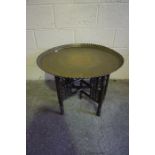 Indian Style Brass Top Table, raised on folding supports, 54cm high, 70cm wide