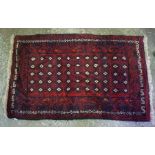 Persian Rug, Decorated with geometric medallions on a red ground, 132cm x 82cm, also with a floral
