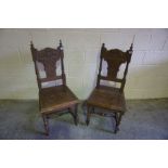 A Pair of Carved Oak Hall Chairs, Carved with panels of scrolls and acanthus leaves, raised on