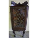 Carved Oak Corner Cabinet, Having a leaded glazed door enclosing a shelved interior, raised on