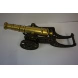 Antique Brass Model of a Cannon, Raised on a tilting iron cart wheel, 18cm high, 47cm long, also