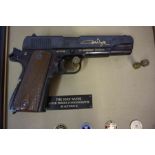 The John Wayne Armed Forces Commemorative Replica 45 Automatic Pistol by Franklin Mint, in a frame