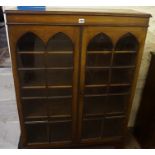 Walnut Bookcase, Having two glazed doors enclosing a shelved interior,