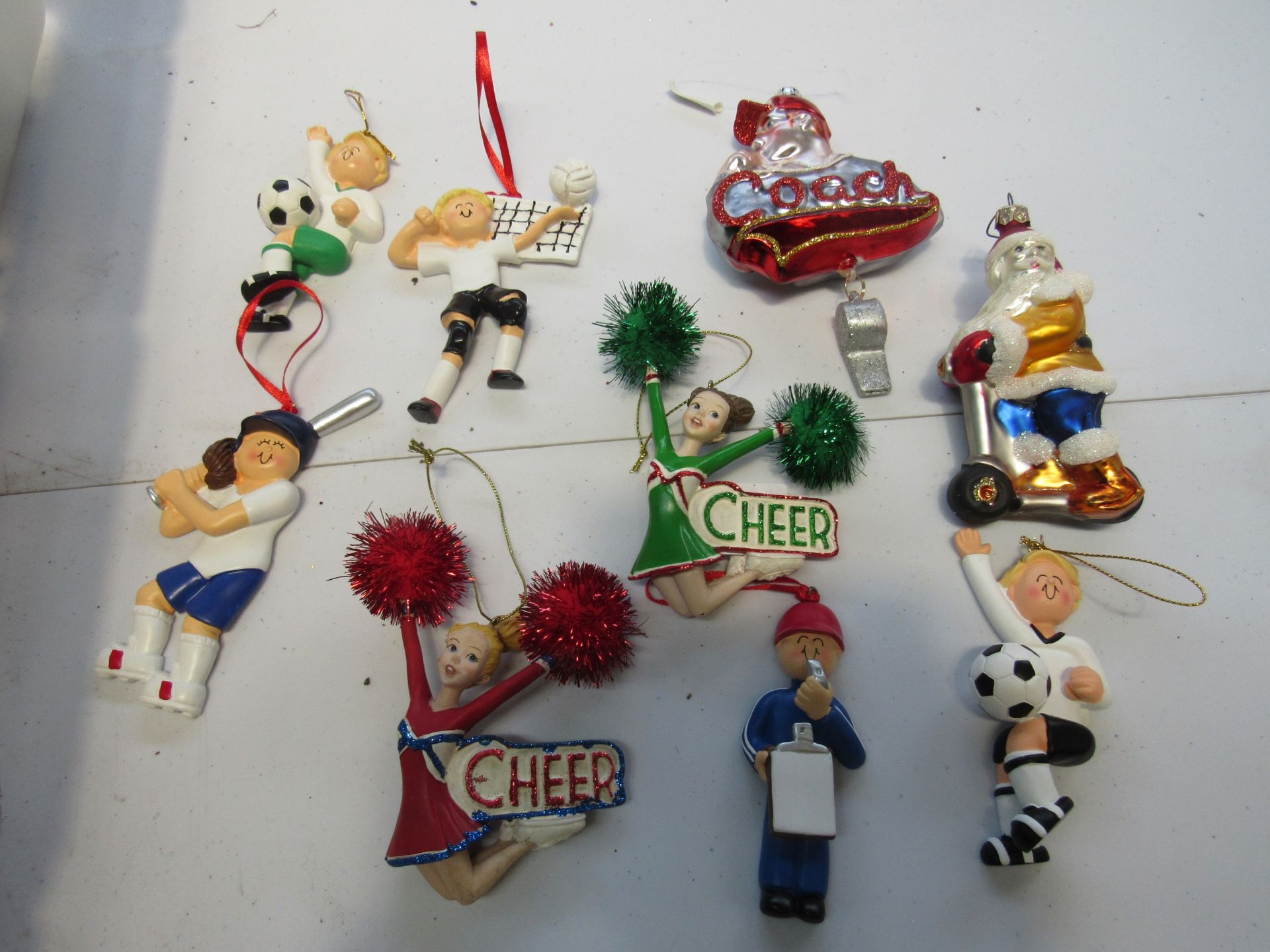 Group of sports themed Christmas ornaments: soccer, volleyball, and cheerleaders