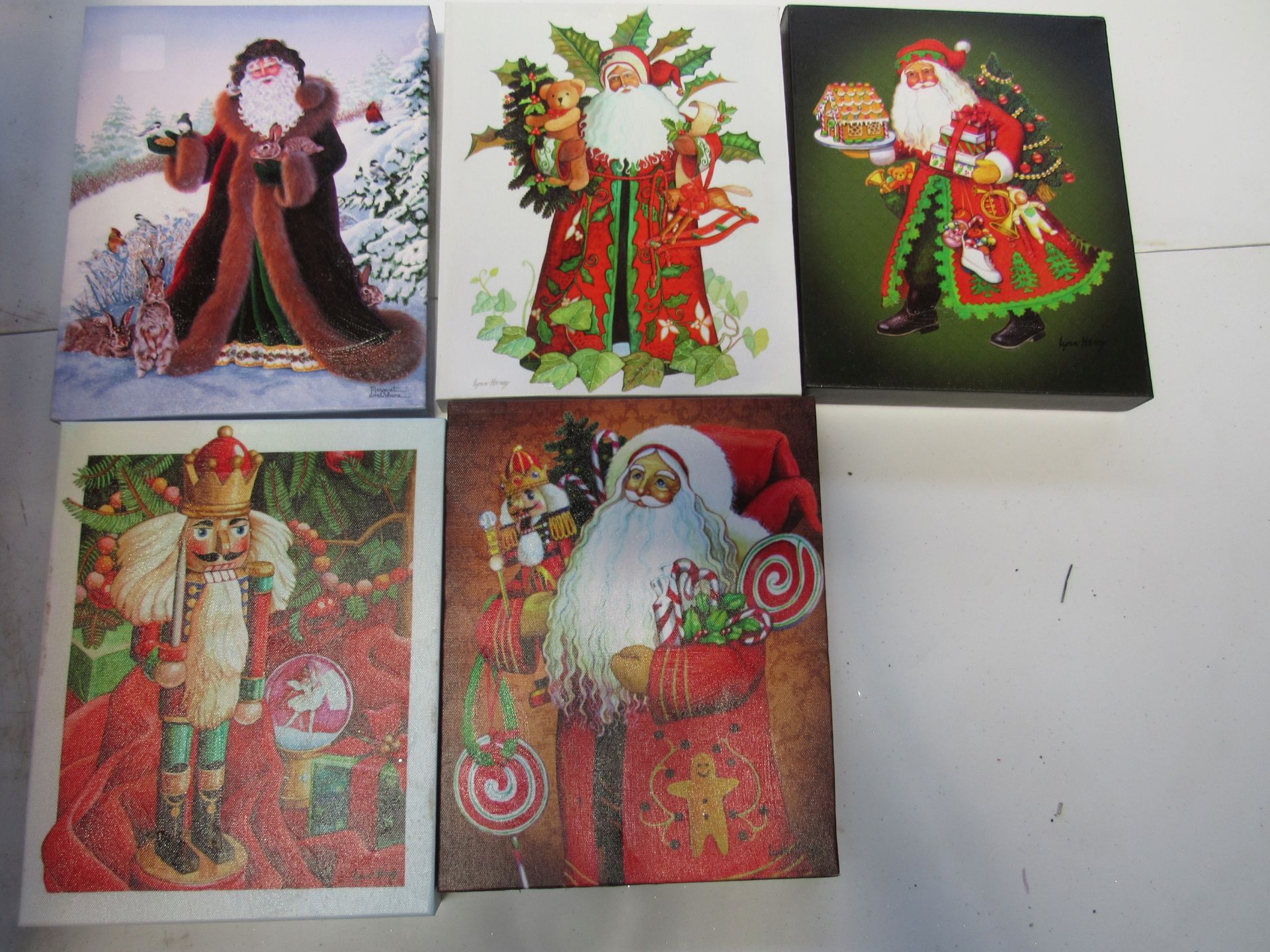 Group of assorted canvas prints depicting Santa Claus